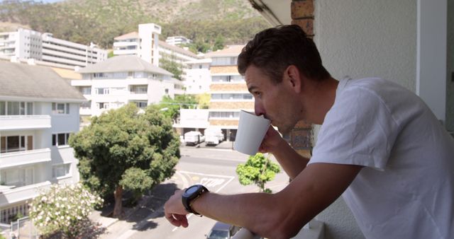 Man Drinking Coffee on Balcony Overlooking Pleasant Urban Neighborhood - Download Free Stock Images Pikwizard.com