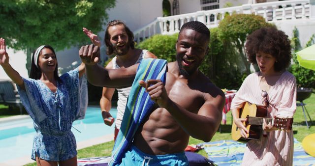 Group of diverse friends having fun and dancing by the pool. One friend plays the guitar while others dance and smile. Their interaction suggests lively energy perfect for summer events, music festivals, and social gatherings. This can illustrate enjoyment and camaraderie in advertisements or social media promotions related to leisure, friendship, and holiday celebrations.