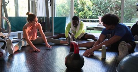 Diverse Group Enjoying Friendly Workout Session At Gym