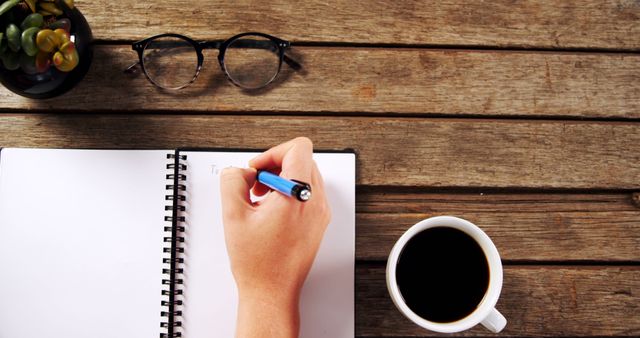 Hand Writing in Notebook with Coffee and Glasses on Wooden Desk - Download Free Stock Images Pikwizard.com