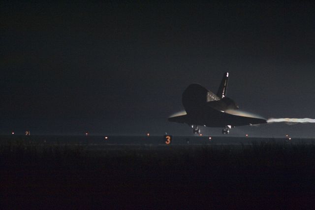 This image captures a dramatic moment as space shuttle Endeavour approaches runway at Kennedy Space Center for its final landing during nighttime. Ideal for use in articles, educational material on space exploration, NASA mission retrospectives, and documentaries.