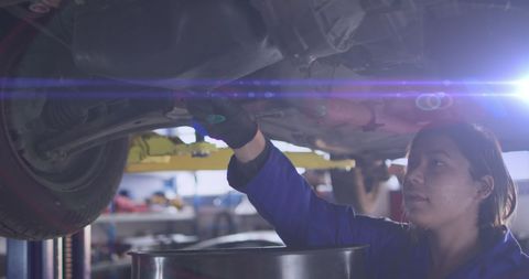 Female Mechanic with Purple Light Effect Repairing Car Undercarriage
