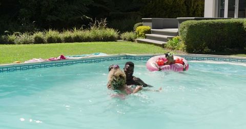 Happy Family Enjoying Relaxation in Backyard Pool