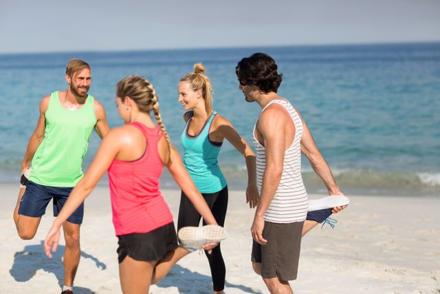 Group of friends stretching and exercising on a sandy beach with the ocean in the background. Ideal for promoting fitness, healthy living, outdoor activities, and social bonding. Perfect for use in advertisements, fitness blogs, travel brochures, and wellness campaigns.