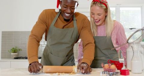 Festive Couple Joyfully Rolling Dough for Holiday Baking
