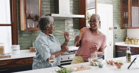 Senior African American Women Enjoying Fun Time in Kitchen