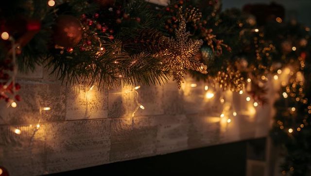 Cozy Christmas mantel garland glowing with warm fairy lights and gold snowflake ornament