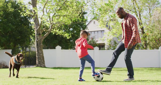 Father bonding with son while playing soccer in sunny backyard, dog joining the fun, perfect for family and outdoor activity themes. Ideal for advertisements, blog posts, and campaigns promoting health, family time, and recreation.