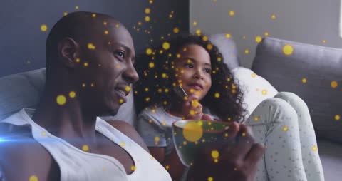 Father and Daughter Relaxing with Sparkling Confetti Lights