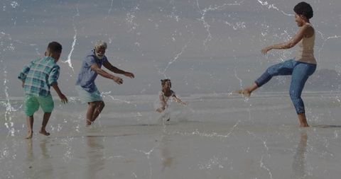Family fun time kicking water at sunny beach
