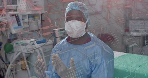 Surgeon Preparing for Operation in Hospital OR with Ventilator Monitors and Sterile Gloves