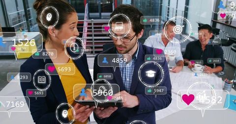 Collaborating professionals using tablet with social media analytics overlays in workspace