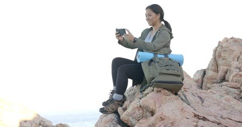 Woman Taking Photo While Hiking on Rocky Mountain