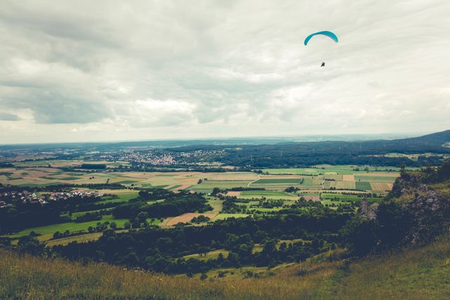 Ideal for promoting outdoor adventures and recreational sports. Suitable for travel brochures, adventure sports magazines, and websites about rural tourism. Could be used in marketing materials for paragliding or nature activities.
