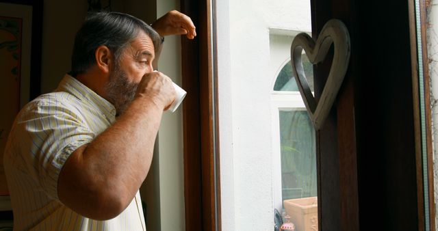 Senior Man Drinking Coffee by Window in Morning Light - Download Free Stock Images Pikwizard.com