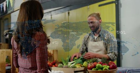 Vendor arranging fresh produce at farmers market with global supply chain digital overlay