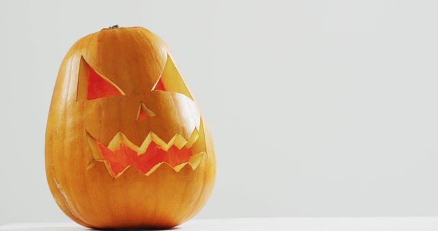 Carved Halloween Pumpkin with Illuminated Face on Light Background - Download Free Stock Images Pikwizard.com