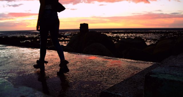 Person Silhouetted Against Ocean Sunset on Reflective Pathway - Download Free Stock Images Pikwizard.com