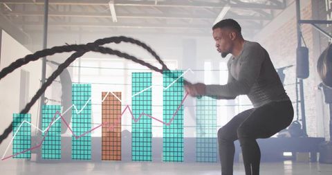 Swinging athlete performing battle ropes with performance data overlay in industrial gym