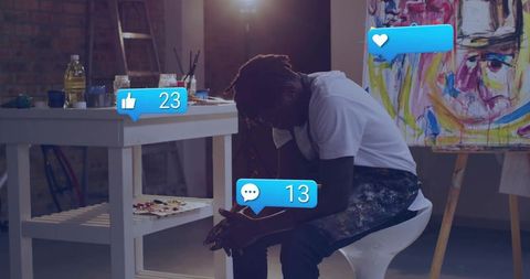 Reflective artist engaging with social media in creative studio