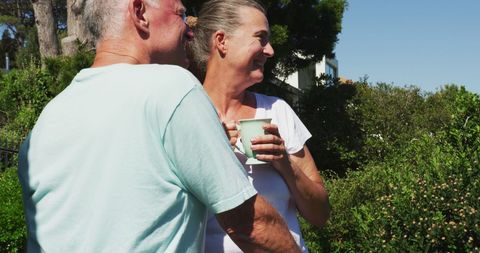Senior Couple Relaxing with Coffee on Sunny Balcony