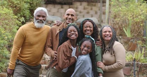 Smiling Diverse Multigenerational Family Embracing on Terraced Stone Steps in Garden