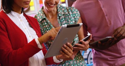 Diverse Business Team Collaborating on Tablet in Office