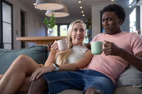 Joyful couple enjoying coffee together at home