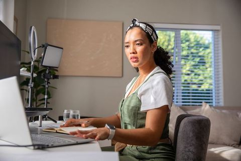 Focused woman engaging in remote work with modern technology setup