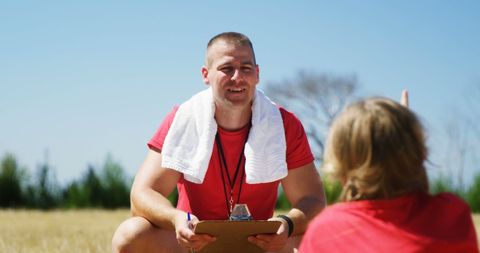 Boot camp trainer guiding child in outdoor exercise session