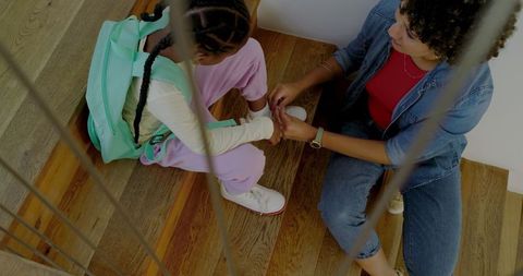 Mother Daughter Bonding on Staircase, Adjusting Sneakers Calmly