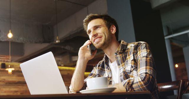 Smiling Man on Phone Working in Modern Cafe - Download Free Stock Images Pikwizard.com