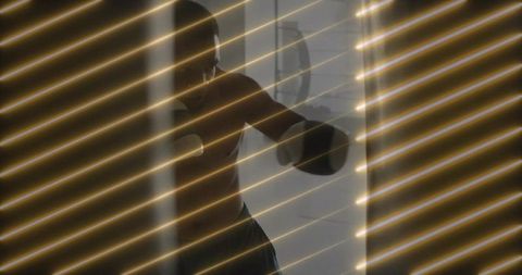 Shirtless boxer training punch combinations with intensity