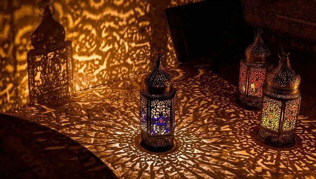 Ornate arabesque lanterns casting intricate lace shadows with colored glass glow