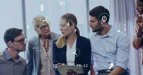 Leading analyst holding tablet presenting energy and emissions data to team in boardroom