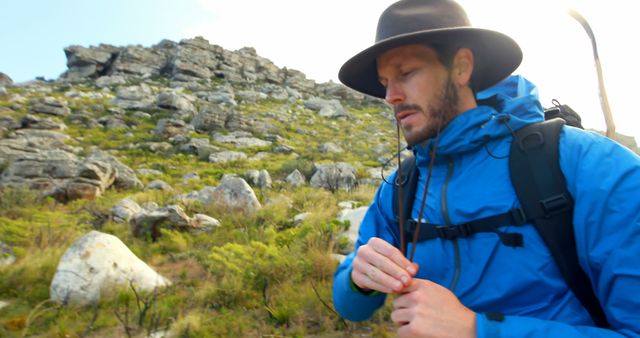 Thoughtful caucasian man wearing hat trekking in wilderness, copy space. Hiking, nature, hobbies, healthy lifestyle and outdoor activities, unaltered.