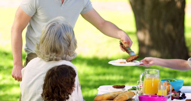 Family Enjoying Outdoor Picnic with Freshly Grilled Food - Download Free Stock Images Pikwizard.com