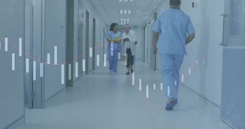 Medical team walking hospital corridor reviewing patient records on tablet and clipboard