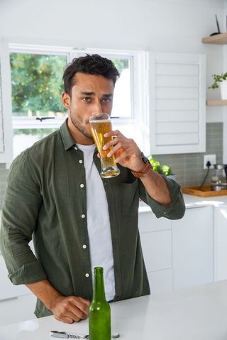 Modern Kitchen Lifestyle with Young Man Enjoying Refreshing Beer