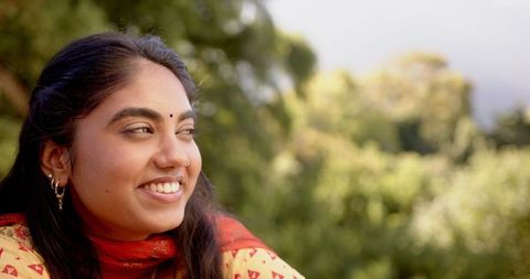 Smiling Indian Woman in Traditional Attire Relaxing Outdoors
