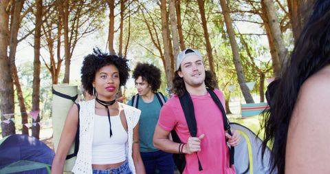 Young adults camping in forest for outdoor festival adventure