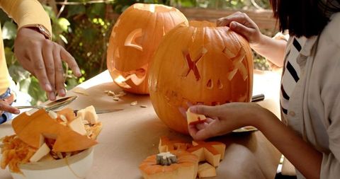 Friends Carving Pumpkins for Halloween on Porch - Download Free Stock Images Pikwizard.com
