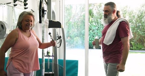 Senior couple exercising together in home gym embracing active lifestyle