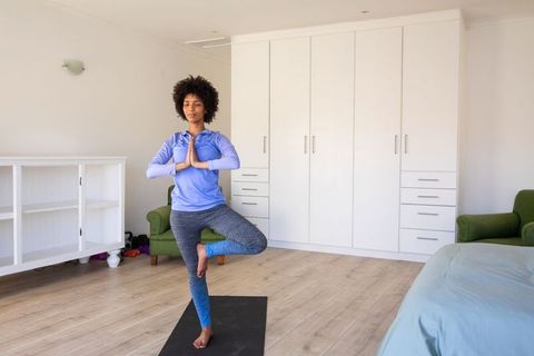 Mindful Woman Practicing Yoga Tree Pose at Home