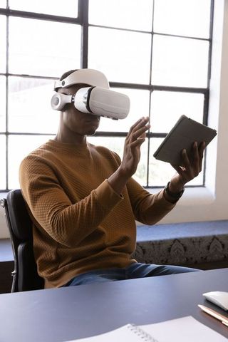 Man Using VR Headset and Tablet in Modern Home Office