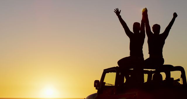 Happy caucasian gay male couple sitting on car raising arms and holding hands at sunset on the beach. summer road trip and holiday in nature.