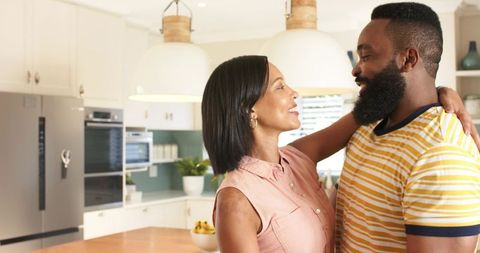 Diverse Couple Embracing in Modern Home Kitchen