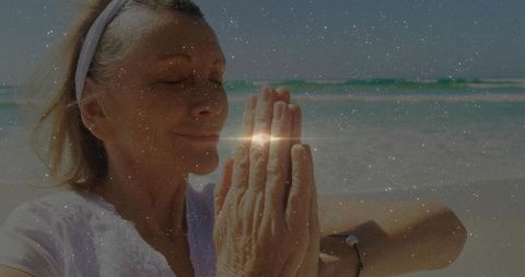Senior Woman Practicing Meditation by Beach with Gentle Waves