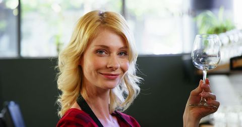Smiling Waitress Holding Wine Glass in Modern Café - Download Free Stock Images Pikwizard.com