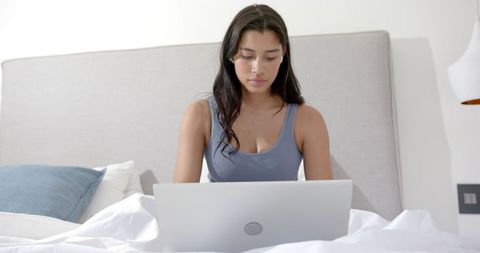 Teenage Girl Working on Laptop in Cozy Bedroom Environment
